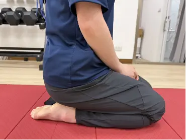 唯心運動醫療體系：物理治療師示範腳背痛舒緩方式：跪姿腳背伸展